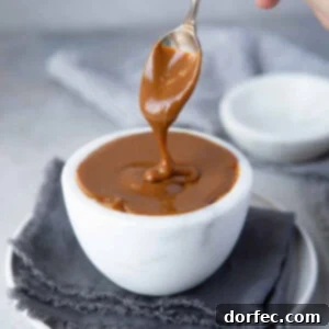 A jar of rich, golden homemade dulce de leche, glistening and ready to be enjoyed.