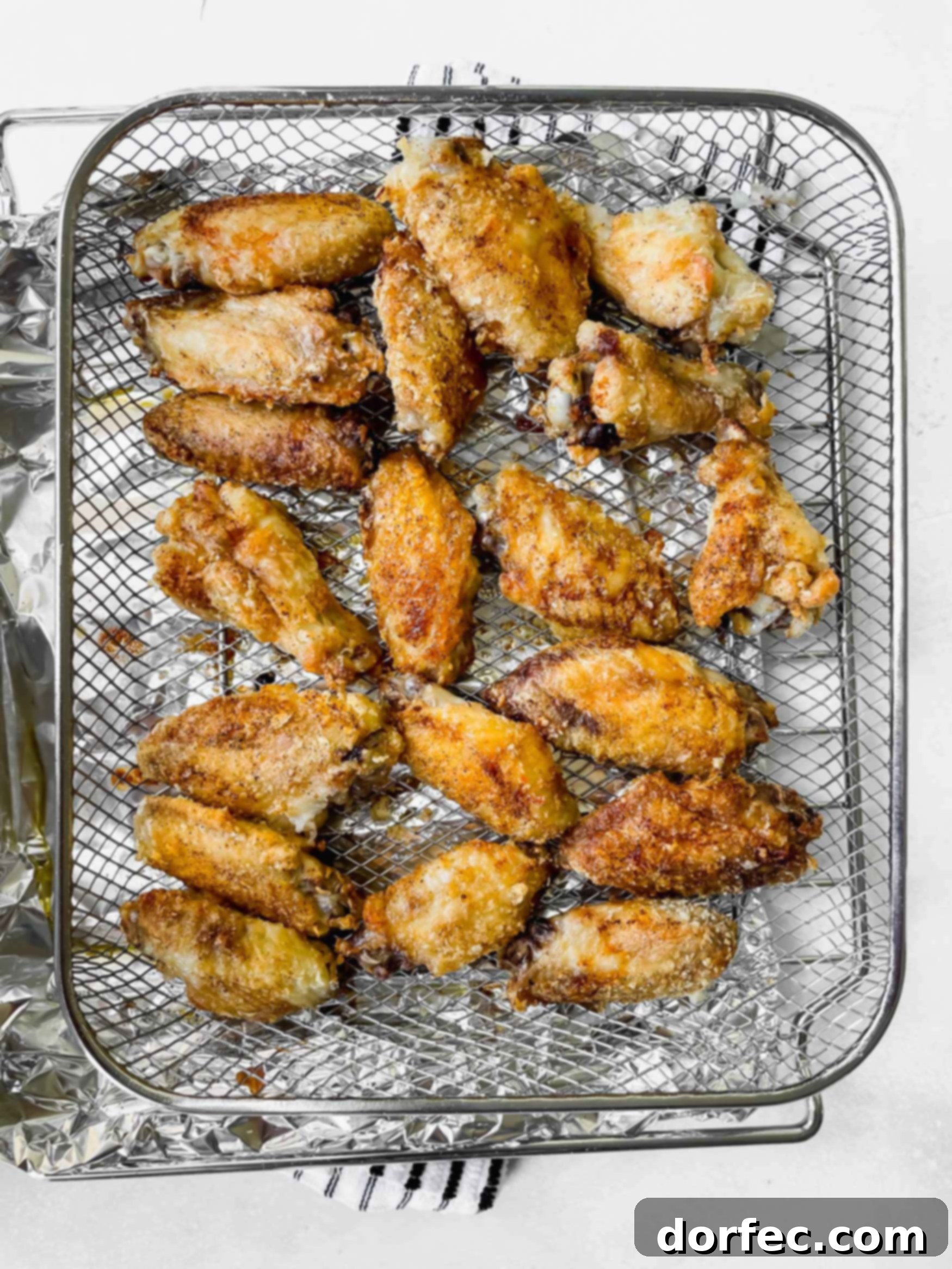 Air Fryer Teriyaki Chicken Wings a photo of a metal cooling rack topped with several crispy chicken wings.