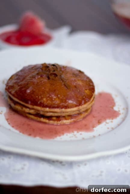 Irresistible Buttermilk Syrup 9 Fluffy chocolate pancakes served with a vibrant strawberry syrup.