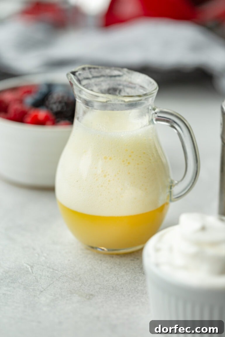 Irresistible Buttermilk Syrup 4 A small glass pitcher of buttermilk syrup captured moments after baking soda was added, showing the characteristic thick foam that develops during the preparation process.