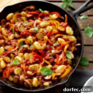 Savory 20-Minute Sausage and Peppers Gnocchi 3 A close-up of a serving of Sausage and Peppers Gnocchi, garnished with fresh parsley.