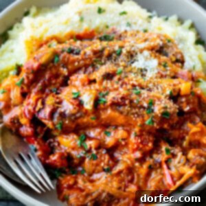 A beautifully presented bowl of creamy Italian sausage and peppers over mashed potatoes, showcasing the rich colors and textures of the dish.