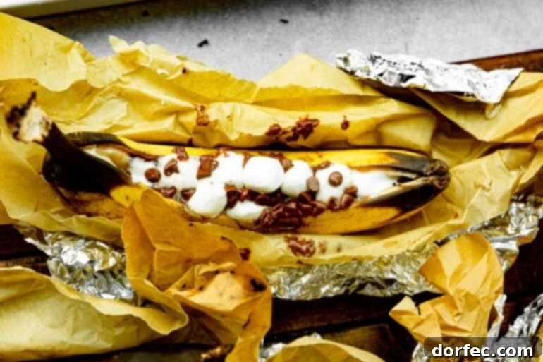 Our Favorite Campfire Banana Boats 3 A perfectly prepared campfire banana boat, split down the middle and generously filled with mini marshmallows and chocolate chips, ready for its foil wrap and roasting over the fire.
