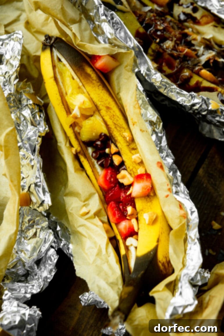Our Favorite Campfire Banana Boats 6 A delightful campfire banana boat, roasted to perfection and adorned with classic banana split toppings like fresh strawberries, chocolate chips, and a sprinkle of nuts.