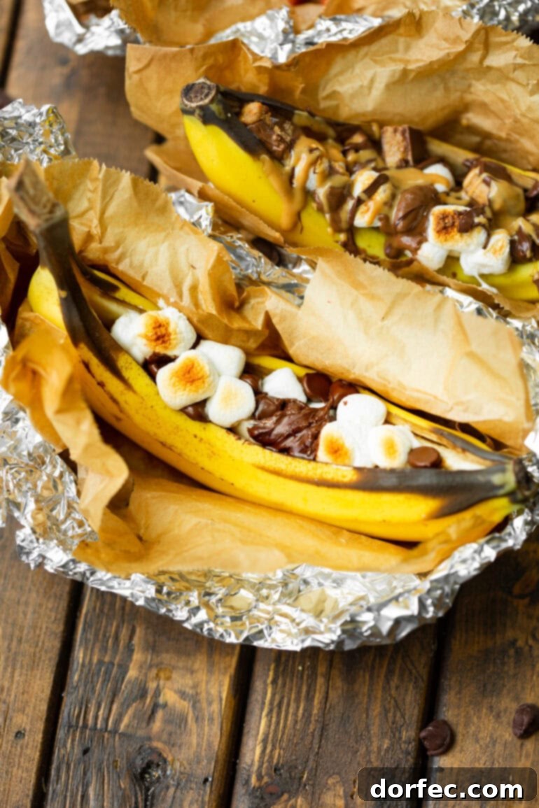 Our Favorite Campfire Banana Boats 7 A perfectly charred campfire banana boat, still in its foil, bursting with gooey melted marshmallows and luscious chocolate chips, ready to be enjoyed.