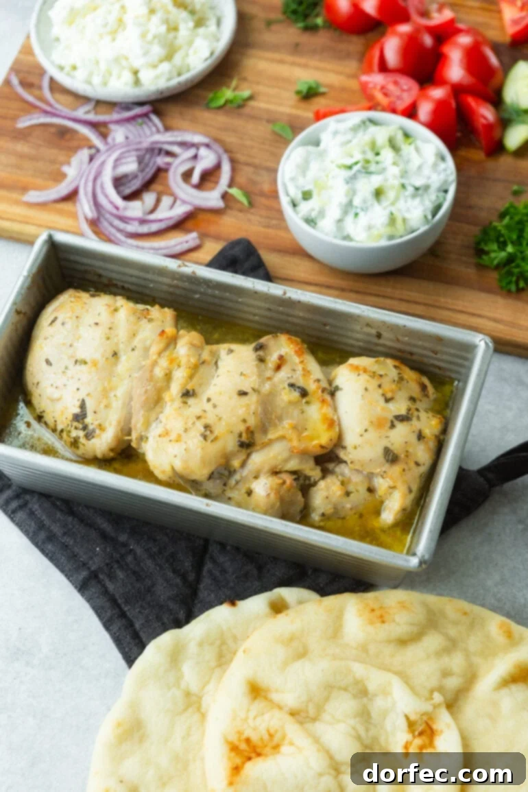 Cade's Signature Chicken Gyros 6 A photo of several baked chicken thighs sitting in a bread loaf pan topped with seasonings.
