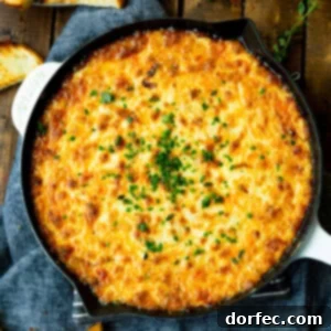 A beautifully presented baked cheesy onion dip in a cast iron skillet.