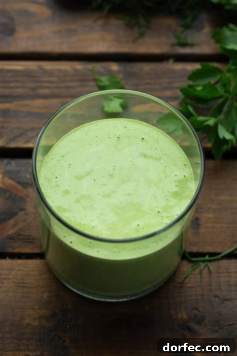A pristine close-up photo of a glass container showcasing the beautiful green hue and creamy texture of homemade basil dressing.