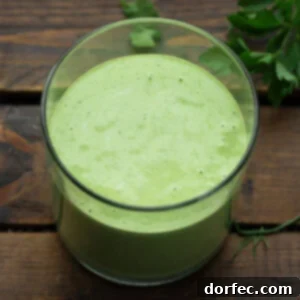 a photo of a glass container full of creamy basil dressing