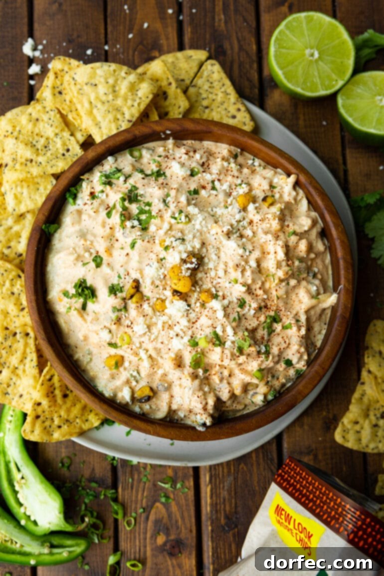 Zesty Mexican Street Corn Dip 6 a photo taken over the top of a bowl of mexican corn dip surrounded by tortilla chips.