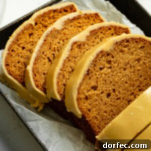 Two slices of homemade apple bread with brown sugar icing on a white dessert plate.
