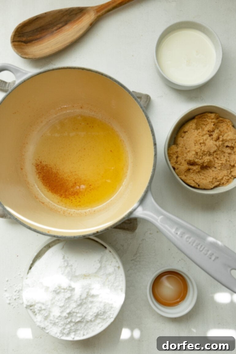 All the ingredients for making cooked brown sugar icing are displayed in individual bowls, including rich browned butter, light brown sugar, whole milk, vanilla extract, and powdered sugar.