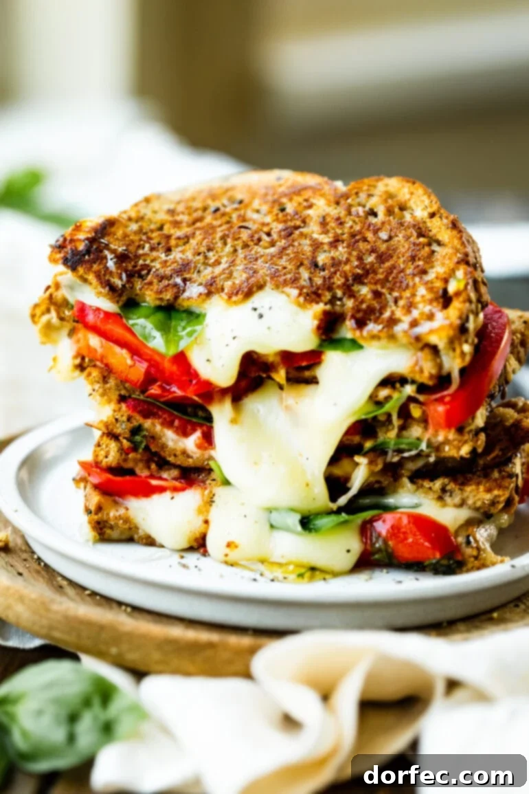 Your Weekly Meal Plan: September 18-24 5 A stack of several perfectly golden-brown, halved Havarti Tomato Basil Grilled Cheese sandwiches, arranged to showcase the luscious melted Havarti cheese oozing out, alongside vibrant slices of red tomato and fresh green basil leaves nestled between perfectly toasted sourdough bread.