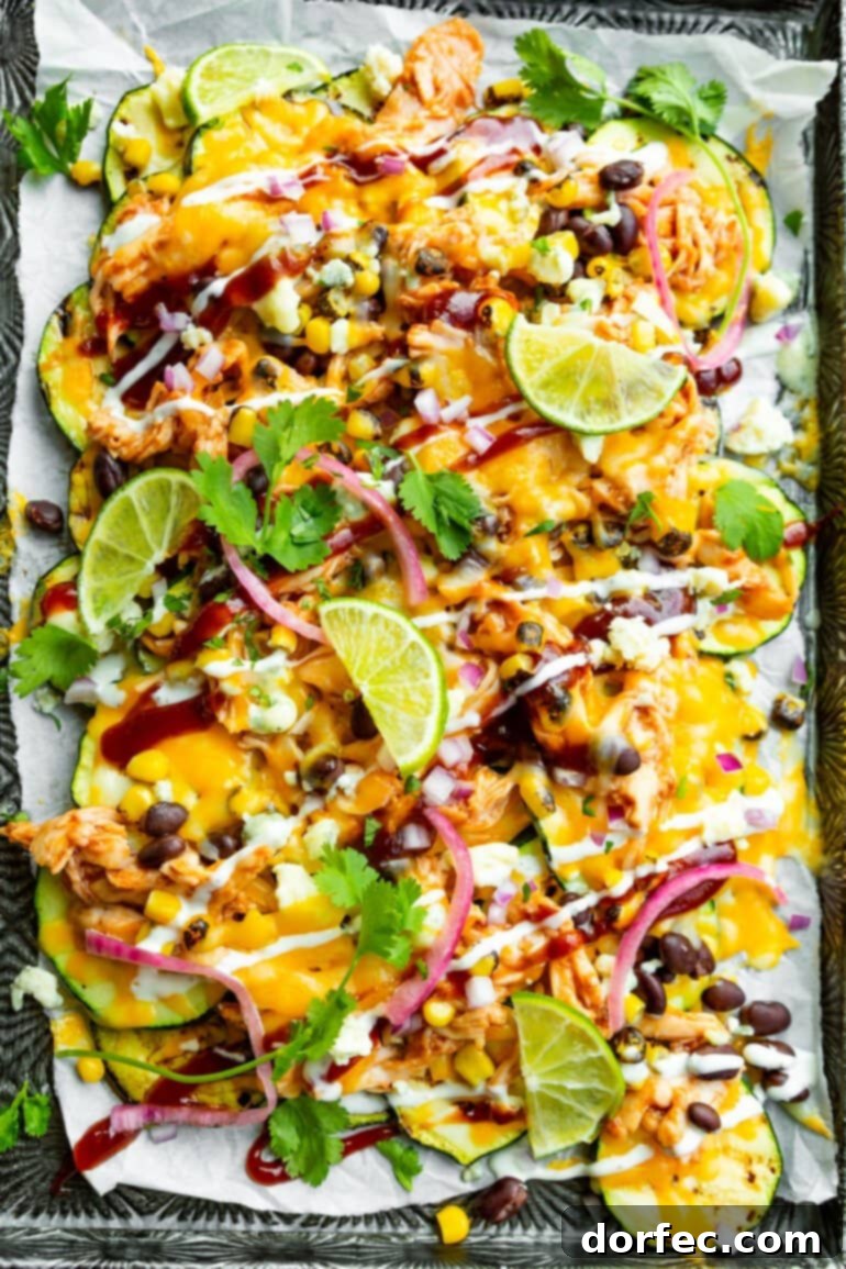 Your Weekly Meal Plan: September 18-24 6 A vibrant sheet pan overflowing with colorful BBQ Chicken Zucchini Nachos, featuring golden-brown melted cheese, tender shredded BBQ chicken, black beans, sweet grilled corn kernels, tangy pickled red onions, fresh cilantro, and a creamy drizzle of white dressing, with bright lime wedges strategically placed on the side.