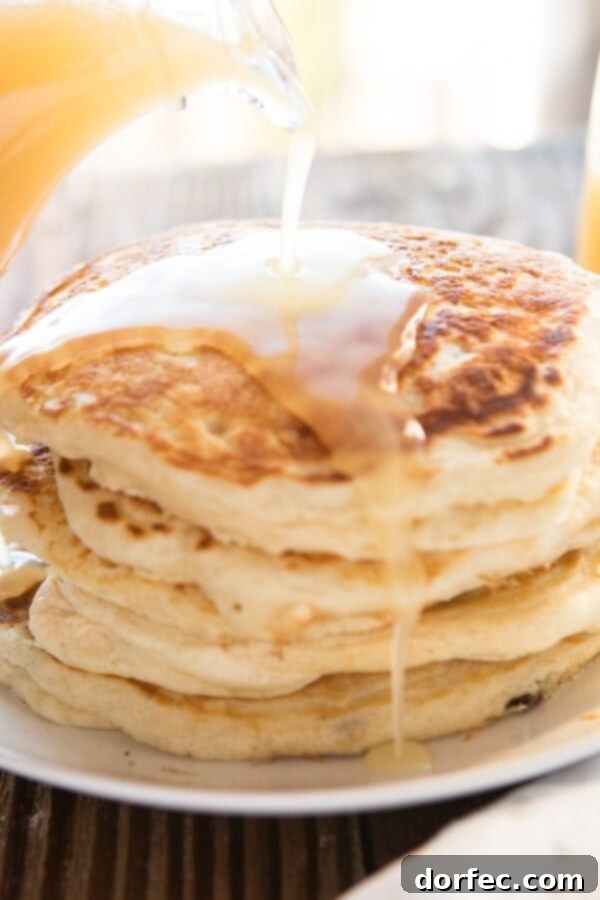 Your Weekly Meal Plan: September 18-24 7 A towering stack of perfectly golden-brown, fluffy buttermilk pancakes, generously drizzled with rich, amber buttermilk syrup, presented on a pristine white plate, ready to be enjoyed as a decadent breakfast or dinner treat.