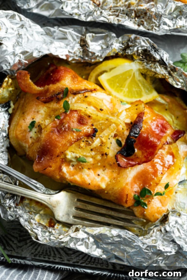 A close-up of a perfectly baked salmon fillet, wrapped in crispy bacon and topped with sweet caramelized onions, fresh herbs, and bright lemon slices.