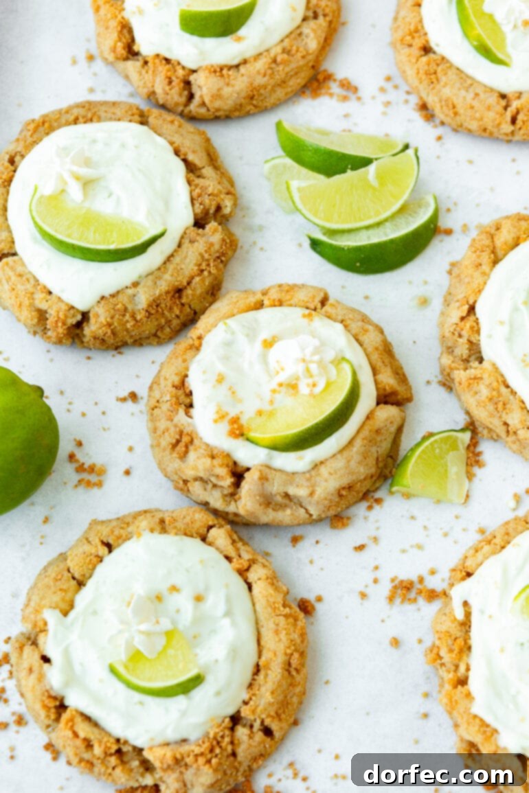 Key Lime Pie Crumbl Cookies 4 A photo of several key lime pie cookies with lime wedges sprinkled around the cookies, highlighting their vibrant freshness.