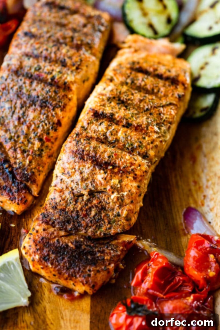 Two perfectly grilled salmon fillets, showcasing beautiful grill marks, are presented on a rustic wooden plank, surrounded by an assortment of vibrant grilled vegetables.