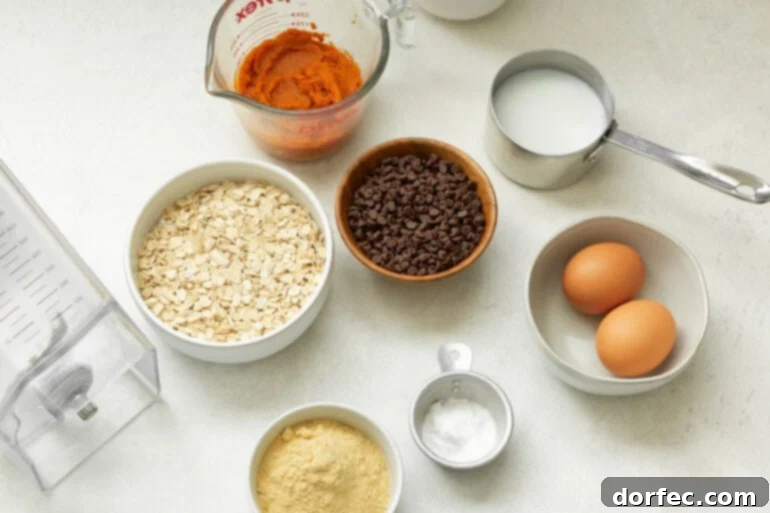 A photo of all the wholesome ingredients neatly arranged for a healthy pumpkin mug cake recipe, including oats, milk, pumpkin puree, and spices.