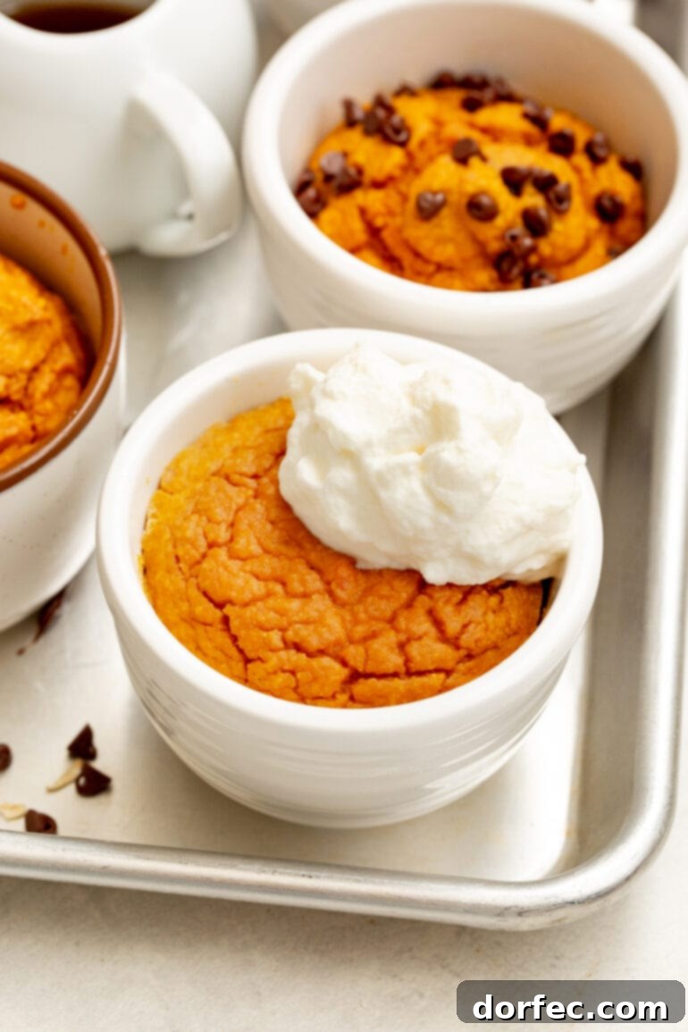 A photo of several baked pumpkin mug cakes with different toppings, including chocolate chips and whipped cream, showcasing customization options.
