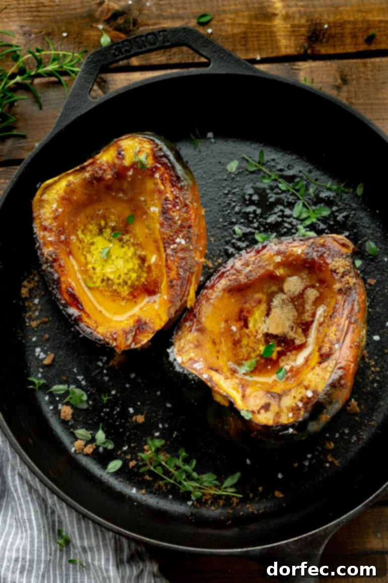 A vibrant photo of an acorn squash that is halved and facing flesh side up, beautifully roasted and caramelized with brown sugar and butter, showcasing its appealing texture.