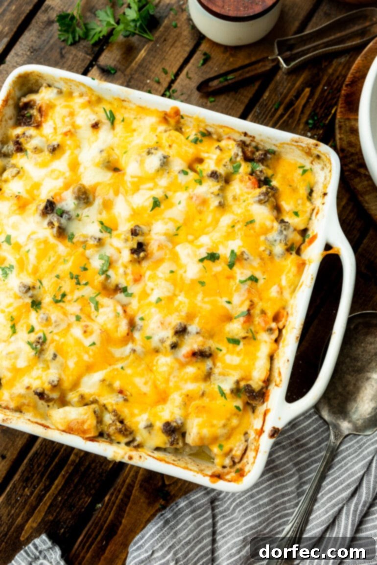 A square casserole dish filled with a hearty and cheesy ground beef and potato casserole, ready to be served. 