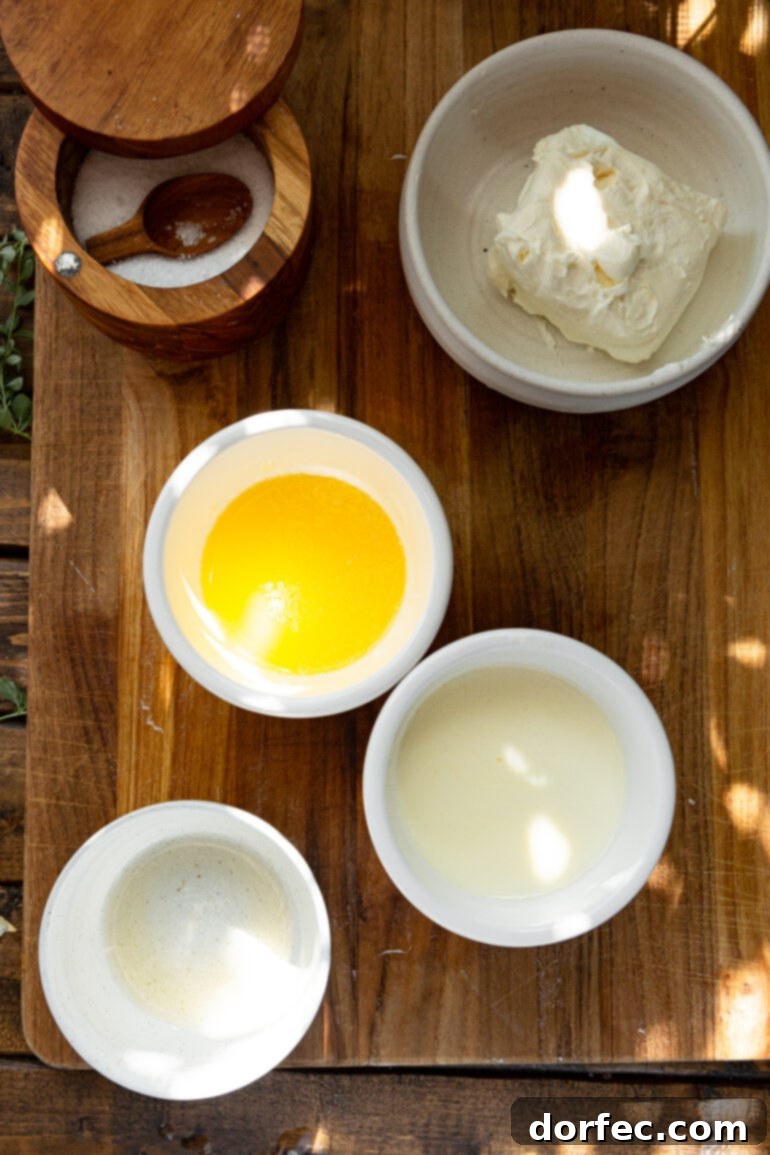 A vibrant flat lay photo displaying all the fresh, simple ingredients laid out in separate small bowls, including softened cream cheese, melted butter, whole milk, and salt, ready to be added to the cooked potatoes for the best creamy mashed potatoes.