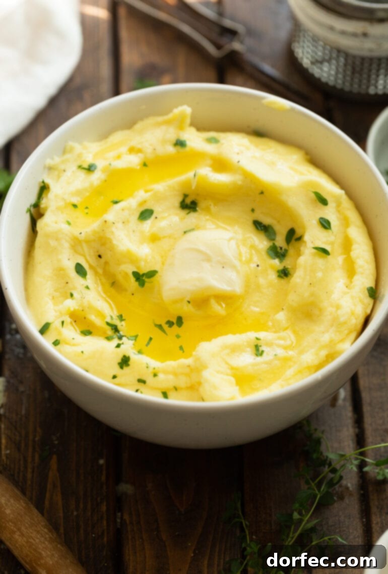 A pristine white ceramic bowl brimming with golden, creamy mashed potatoes, elegantly garnished with a melting pat of butter and a delicate sprinkle of fresh green herbs, a picture of culinary comfort.