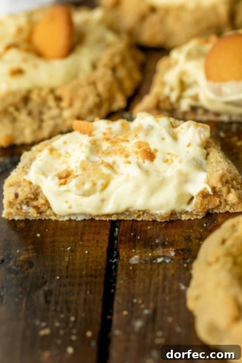 Giant Banana Cream Pie Cookies 3 a photo taken from the side of a banana cream pie cookie that has been cut in half so that you can see the creamy cross-section