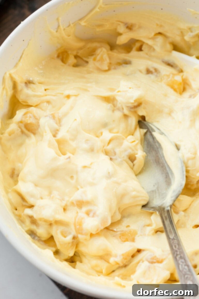 Giant Banana Cream Pie Cookies 5 a photo taken over the top of a large bowl full of creamy banana pudding being stirred with a spoon