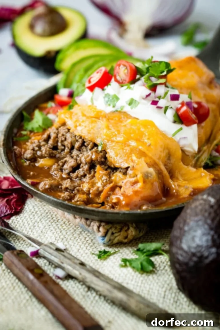 Weekly Meal Plan October 23-29 3 A plate of enchilada style ground beef burritos, topped with melted cheese and a rich red sauce, ready to be enjoyed.