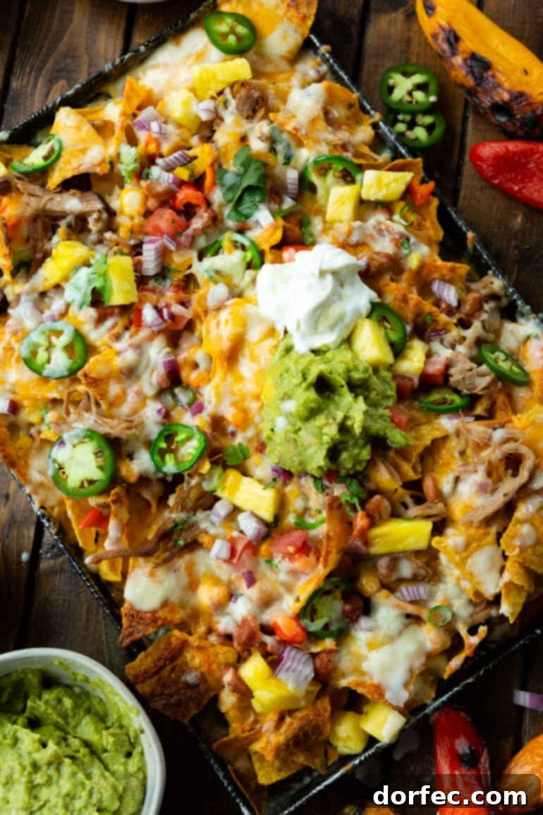 Weekly Meal Plan October 23-29 6 a photo taken over the top of a sheet pan full of pulled pork nachos topped with melted cheese and all your favorite nacho toppings.