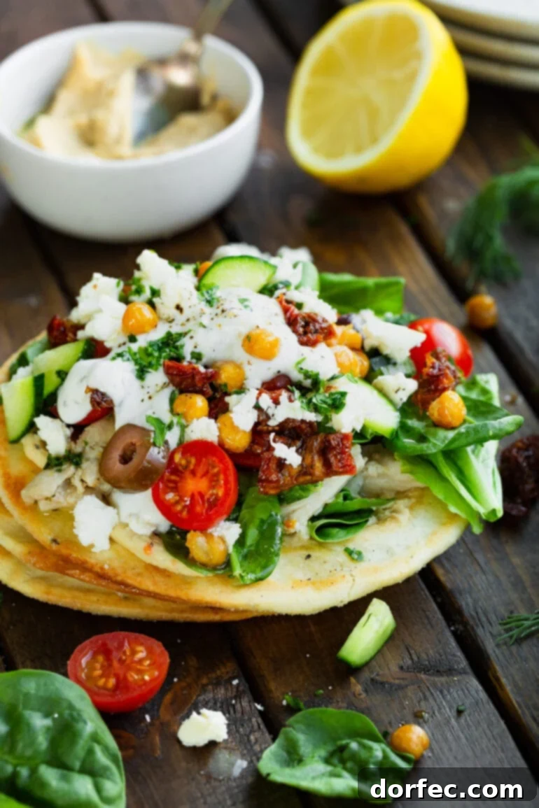 Weekly Meal Plan October 23-29 7 a photo of a Greek tostada topped with tomatoes, olives, feta cheese chickpeas and tzatziki sauce.