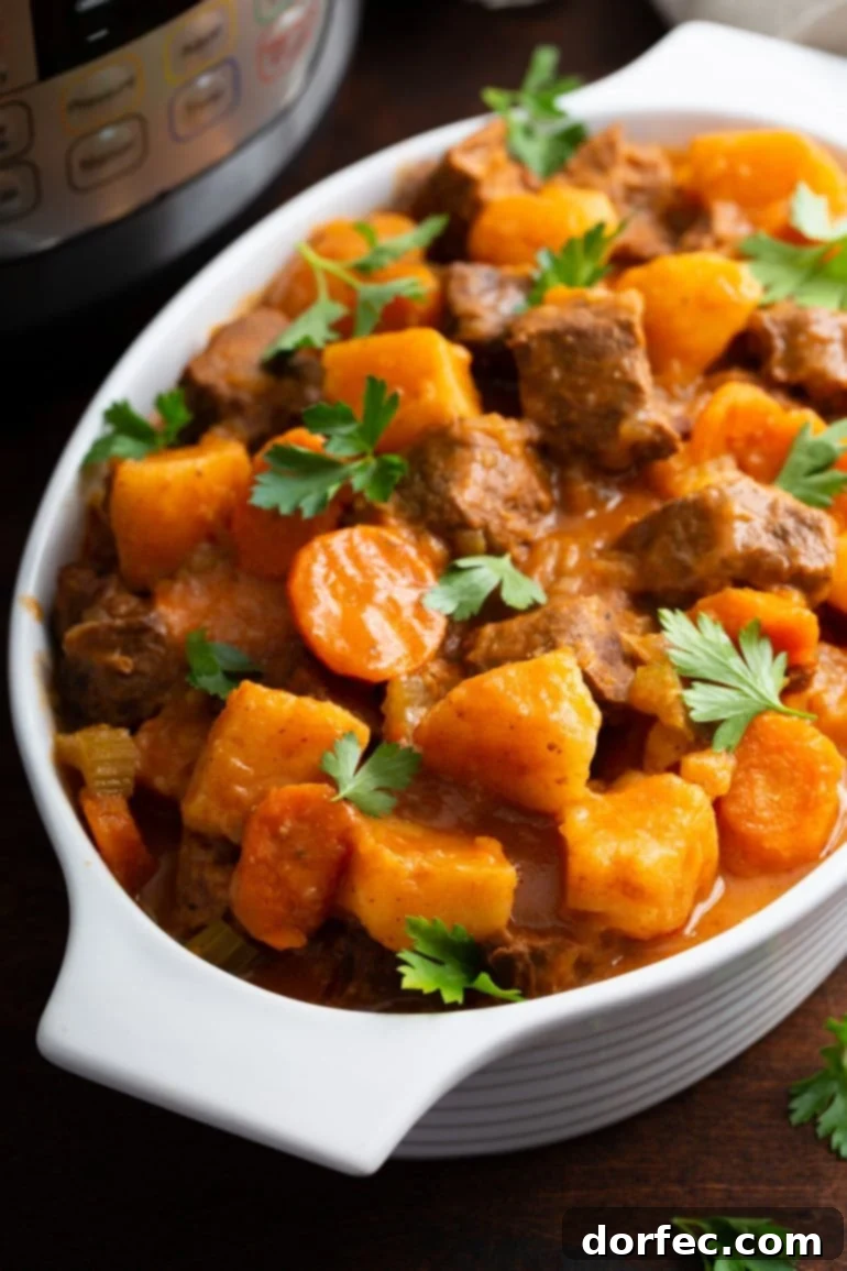 Weekly Meal Plan October 23-29 9 A serving bowl of instant pot beef stew. There are chunks of beef, carrots, and potatoes. Fresh parsley leaves are scattered on the top.