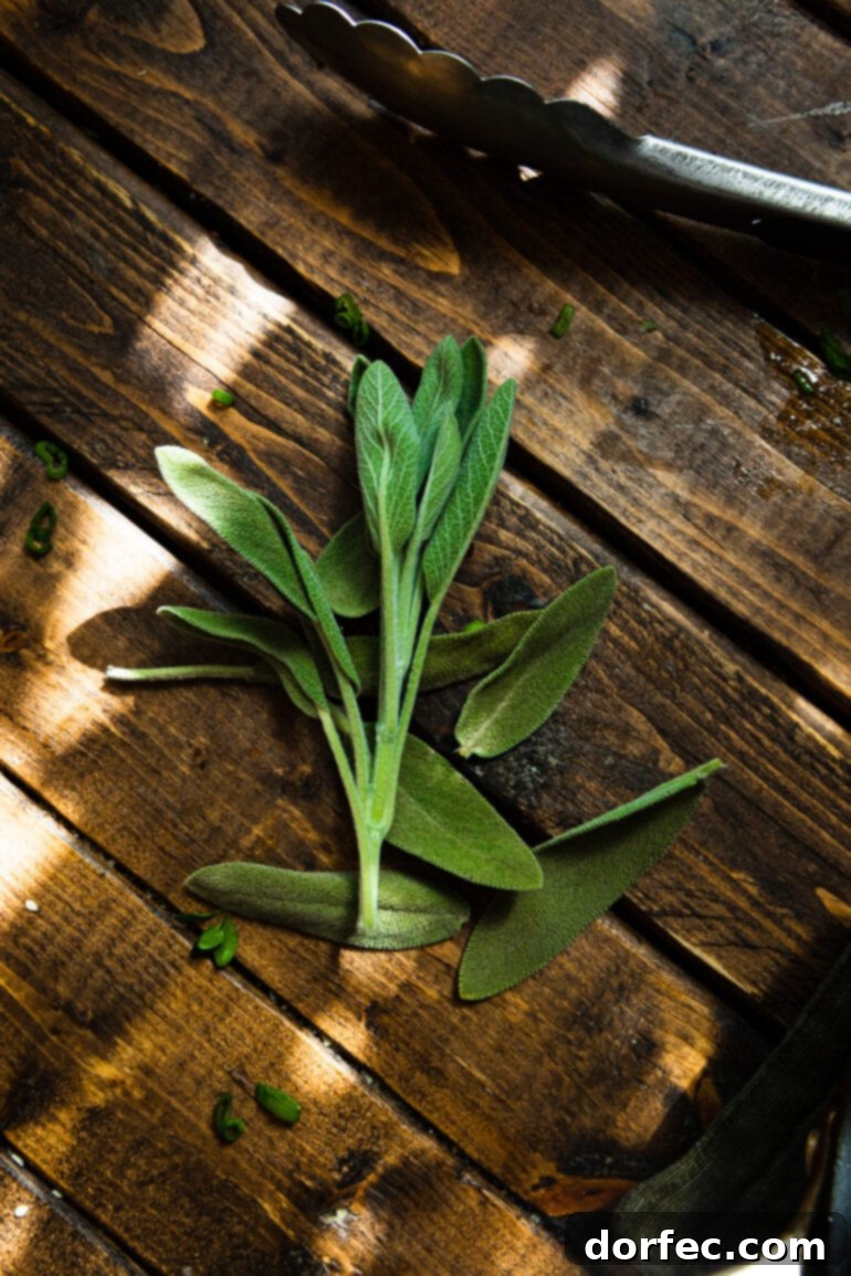 Heartwarming Holiday Acorn Squash 9 A rustic bundle of fresh sage leaves, tied together, resting on a textured wooden table, ready for culinary use.