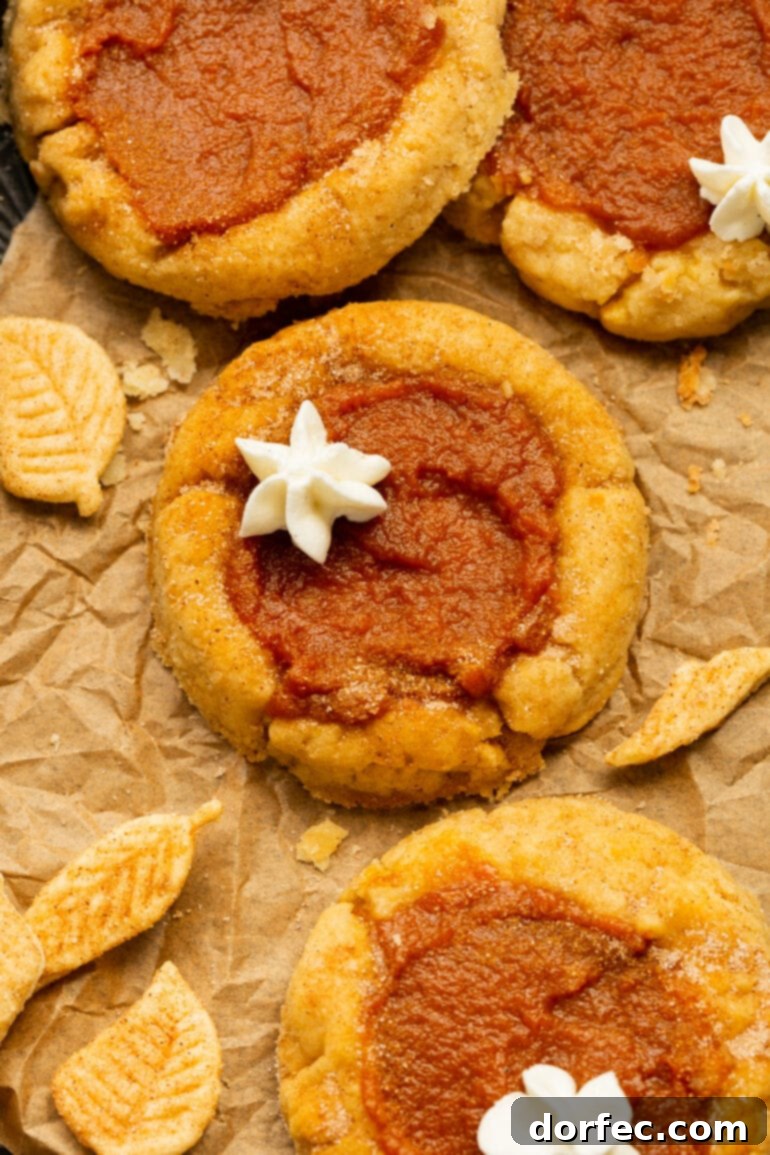 Delightfully Soft Chewy Pumpkin Pie Spice Cookies 2 Several soft and chewy pumpkin pie cookies, each topped with a delicate swirl of whipped cream, invitingly arranged on a platter, ready for a delicious fall treat.