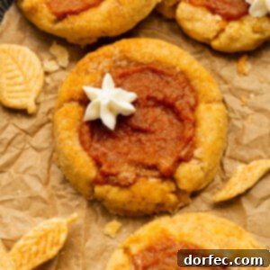 Delightfully Soft Chewy Pumpkin Pie Spice Cookies 10 a photo of several pumpkin pie cookies topped with a little dollop of whipped cream.