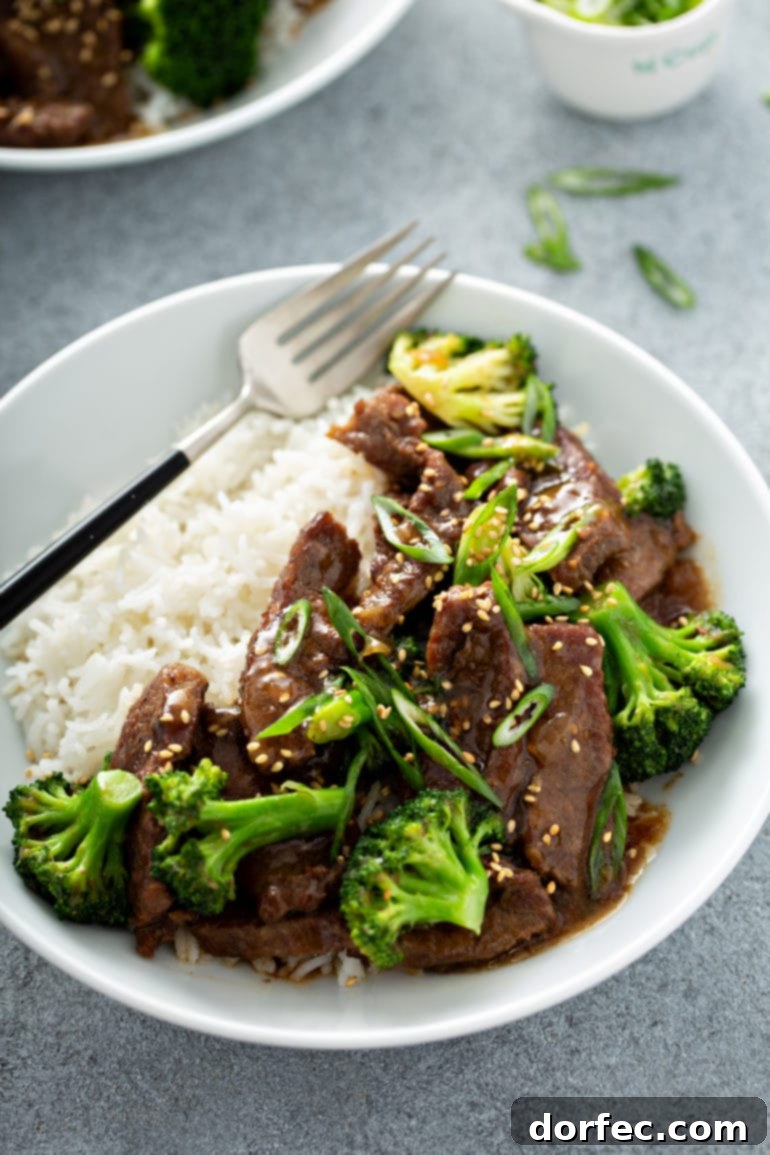 Effortless Weekly Menu November 20 to 26 8 A perfectly composed bowl containing a generous serving of fluffy white rice, artfully topped with savory Instant Pot beef and vibrant green broccoli florets. A fork rests alongside, inviting you to enjoy this delicious and healthy Asian-inspired meal.
