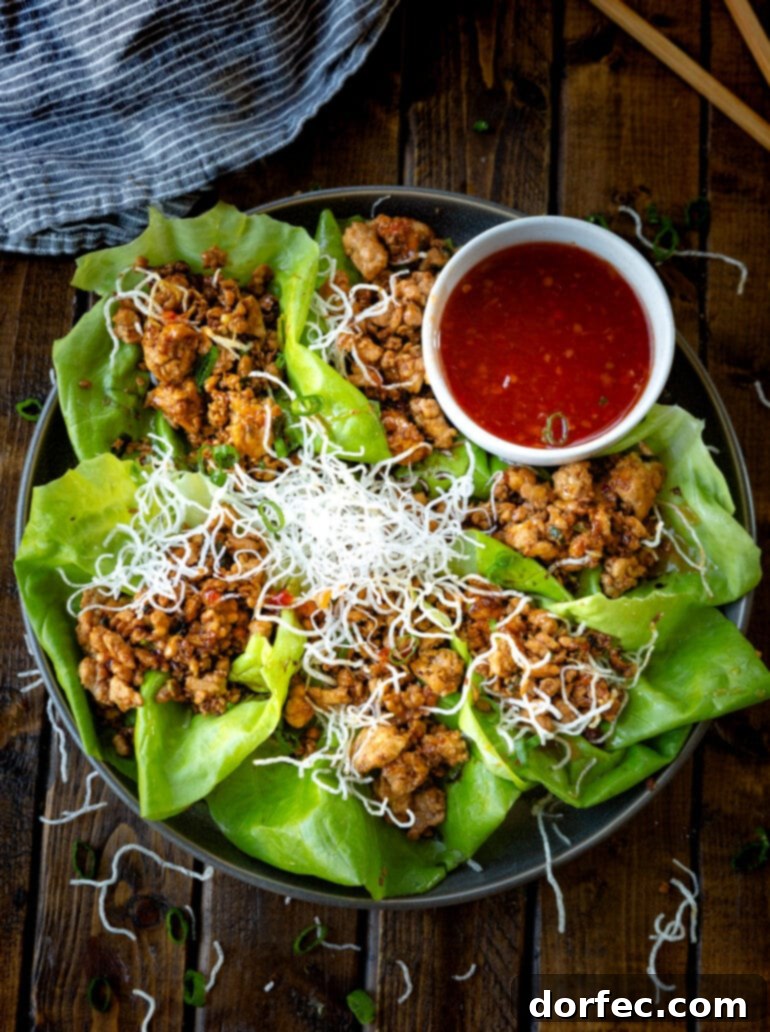 Weekly Meal Plan: December 11-17 6 A large, inviting platter abundantly filled with several vibrant Asian chicken lettuce wraps, accompanied by a small, elegant bowl of savory sweet chili dipping sauce for extra flavor.