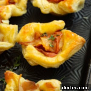 A photo of several puff pastry bites filled with roasted pear, prosciutto, thyme and hot honey