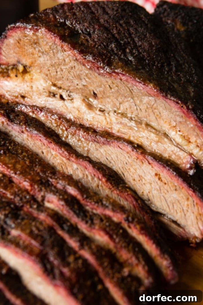 A photo of perfectly smoked brisket, expertly sliced to reveal a prominent smoke ring and juicy texture.