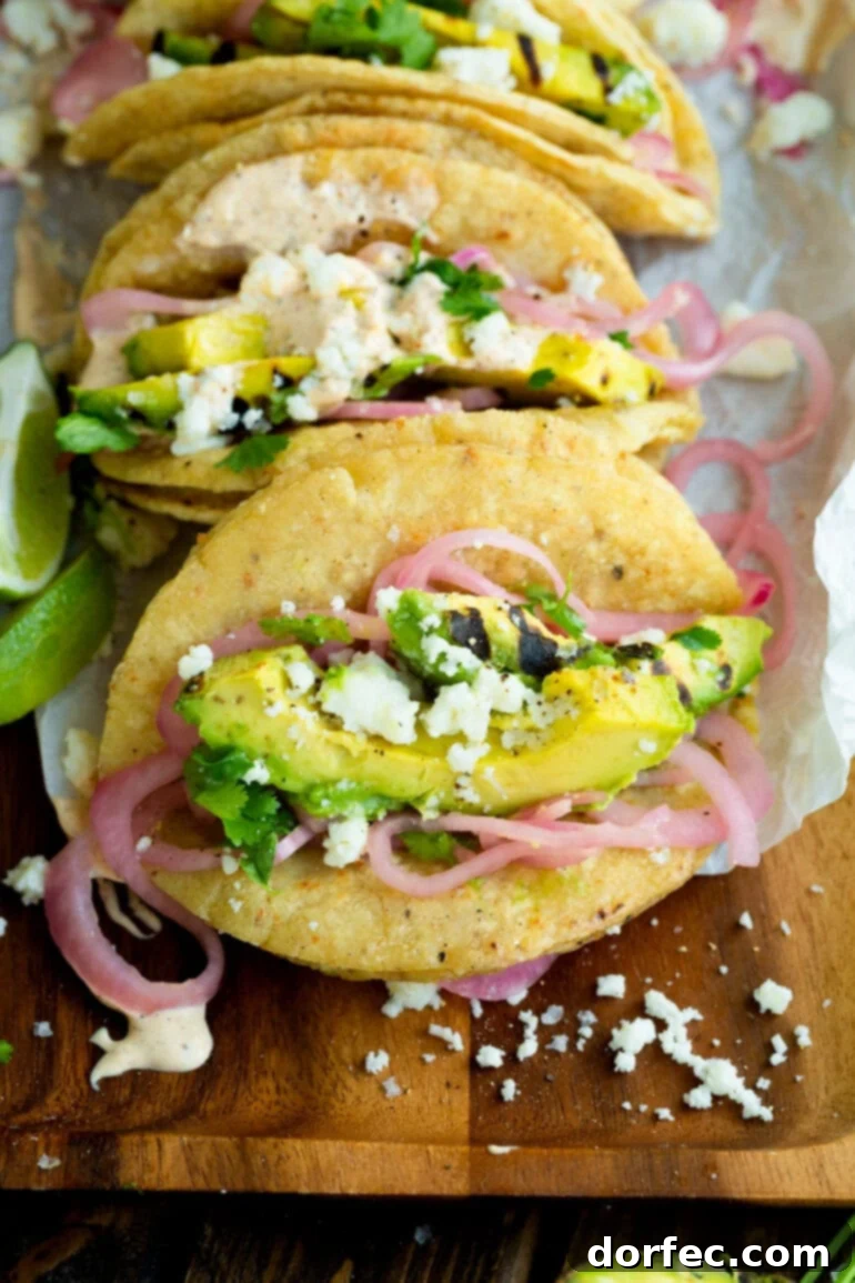 Weekly Meal Plan January 1-7 4 a photo taken over the top of a taco filled with slices of grilled avocado, pickled red onions, crumbly queso fresco, and a little salt and pepper, highlighting a unique vegetarian taco experience.