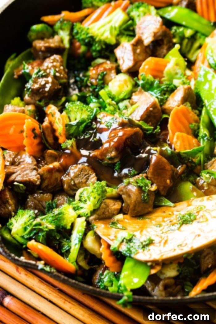 Weekly Meal Plan January 1-7 5 A photo of sesame steak stir fry loaded with vibrant vegetables and topped with sesame seeds, presenting a quick and healthy dinner option.