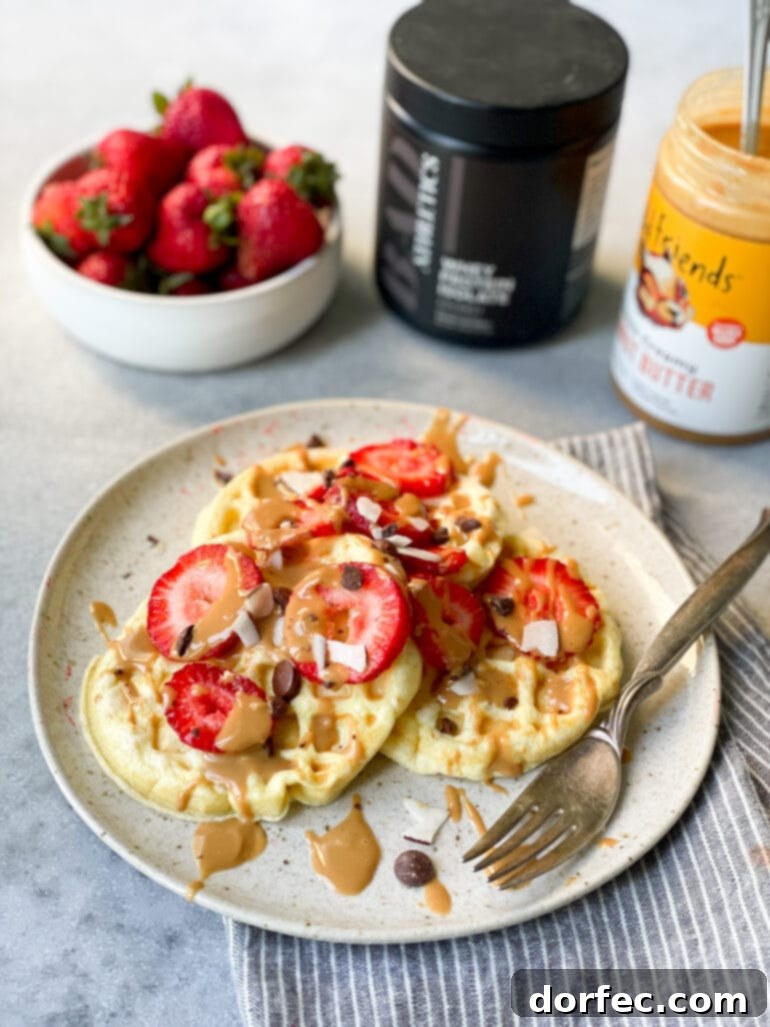 Weekly Meal Plan January 1-7 7 a photo with three small circular waffles sitting on a white dinner plate topped with sliced strawberries, chocolate chips, and peanut butter drizzle, alongside fresh ingredients.