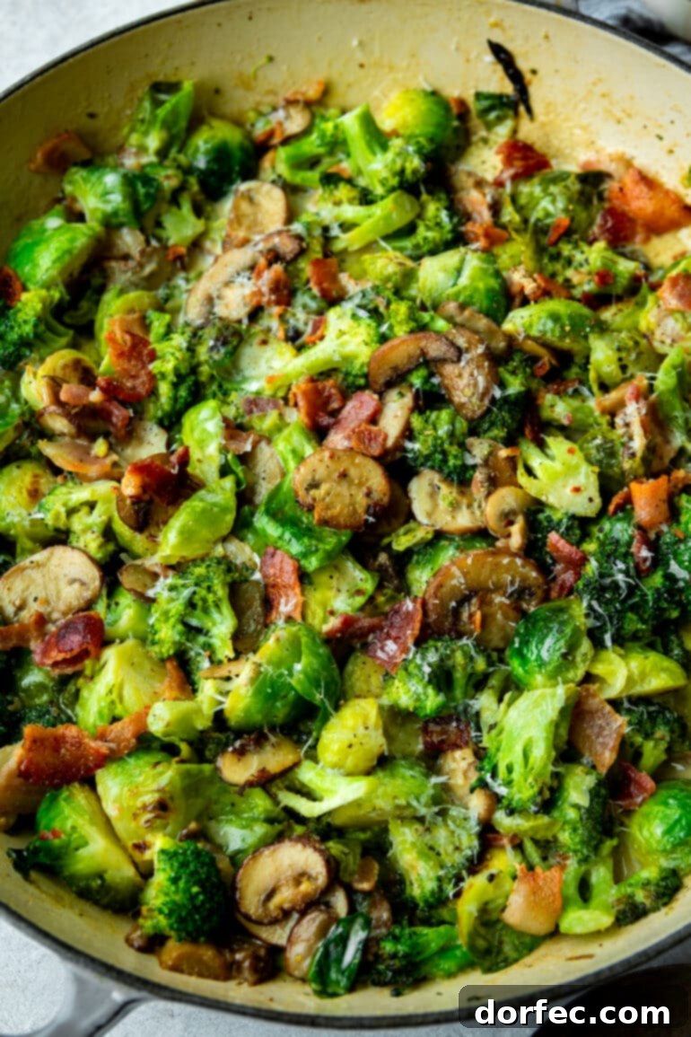 a photo of a cast iron skillet full of creamy brussel sprouts and broccoli mixed with crispy bacon bits and sliced mushrooms