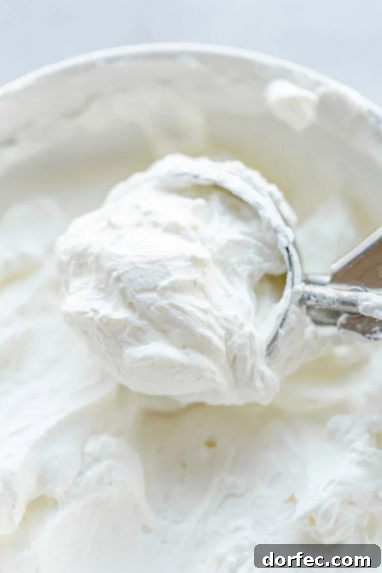 a photo of someone scooping up from thick and fluffy mascarpone whipped cream