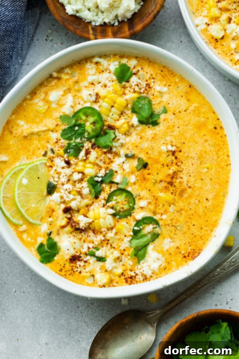 Elote Corn Soup 2 A large bowl of creamy Mexican Street Corn Soup, garnished with vibrant sliced jalapeños, fresh chopped cilantro, and bright lime wedges. This quick and easy soup brings the classic Elote flavors to your dinner table.