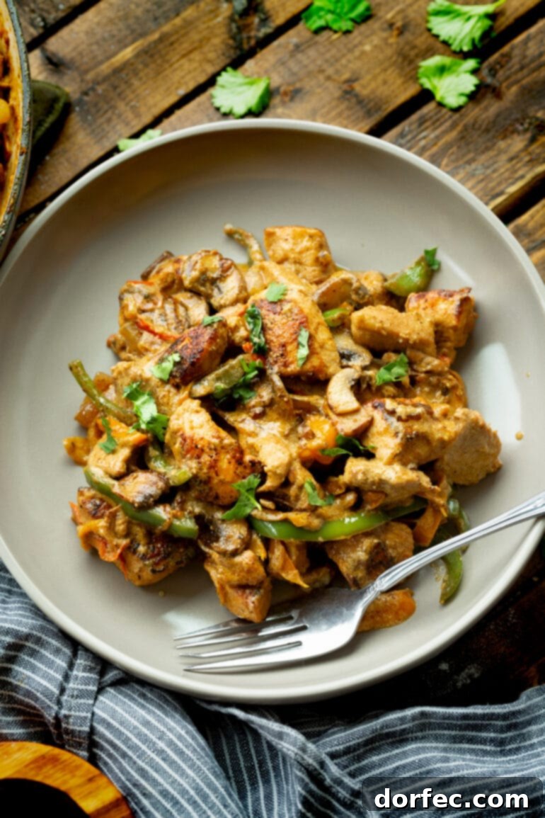A photo of a dinner plate featuring a generous serving of Pollo a la Crema, garnished with fresh cilantro, ready to be enjoyed.