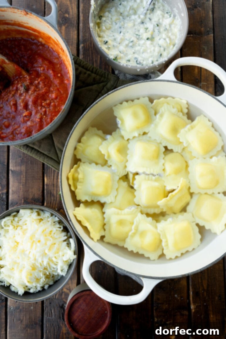 Effortless Skillet Ravioli Lasagna 4 A photo of all the ingredients for lazy lasagna laid out in separate bowls, including cooked ravioli, a rich red meat sauce, shredded parmesan, and a creamy cheese filling.