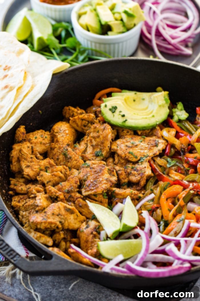 Weekly Meal Plan March 11-17 3 A photo of a bubbling cast iron skillet, perfectly seared chicken fajita filling, colorful sauteed peppers and onions, bright lime wedges, thinly sliced purple onion, and creamy sliced avocados, all ready to be scooped into tortillas.
